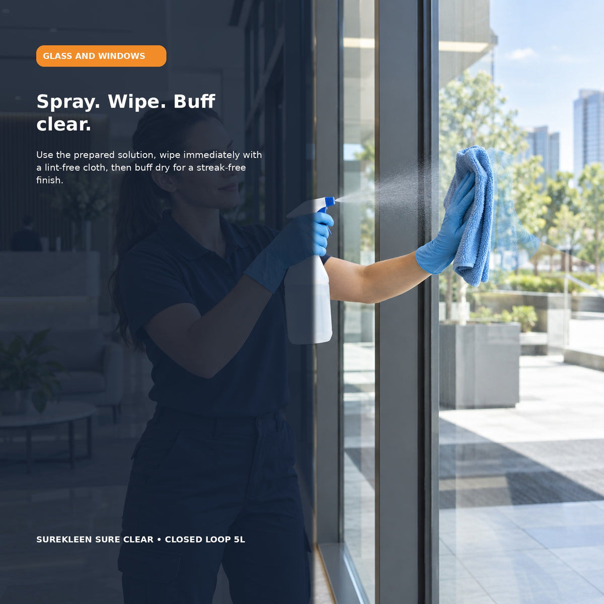 Professional cleaner spraying and wiping a commercial glass window
