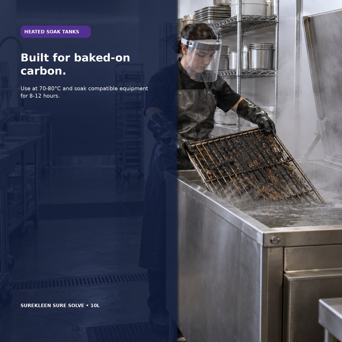 Worker in protective equipment lowering a carbonised oven rack into a commercial soak tank
